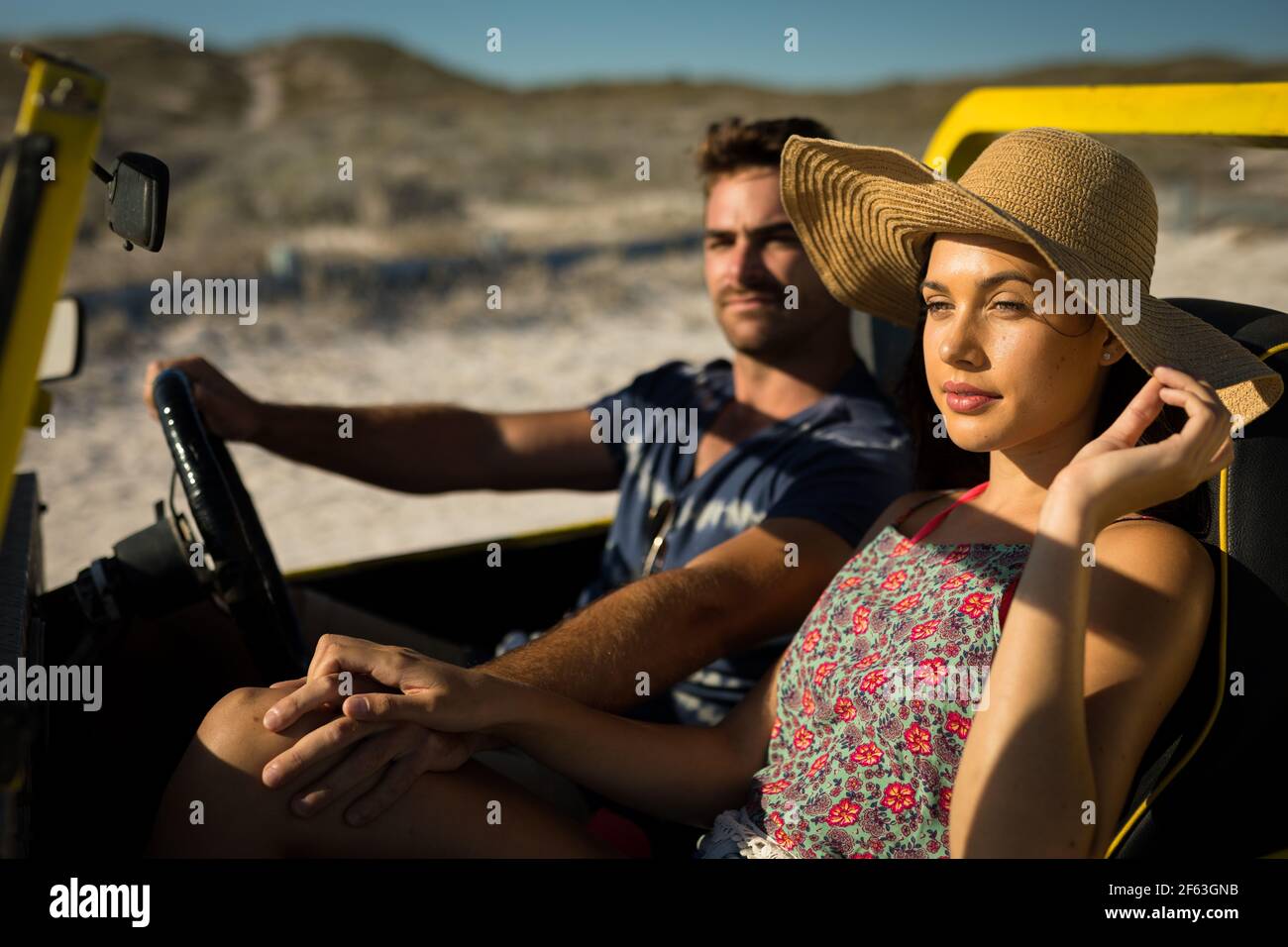 Heureux couple caucasien assis dans la plage buggy au bord de la mer tenir les mains Banque D'Images