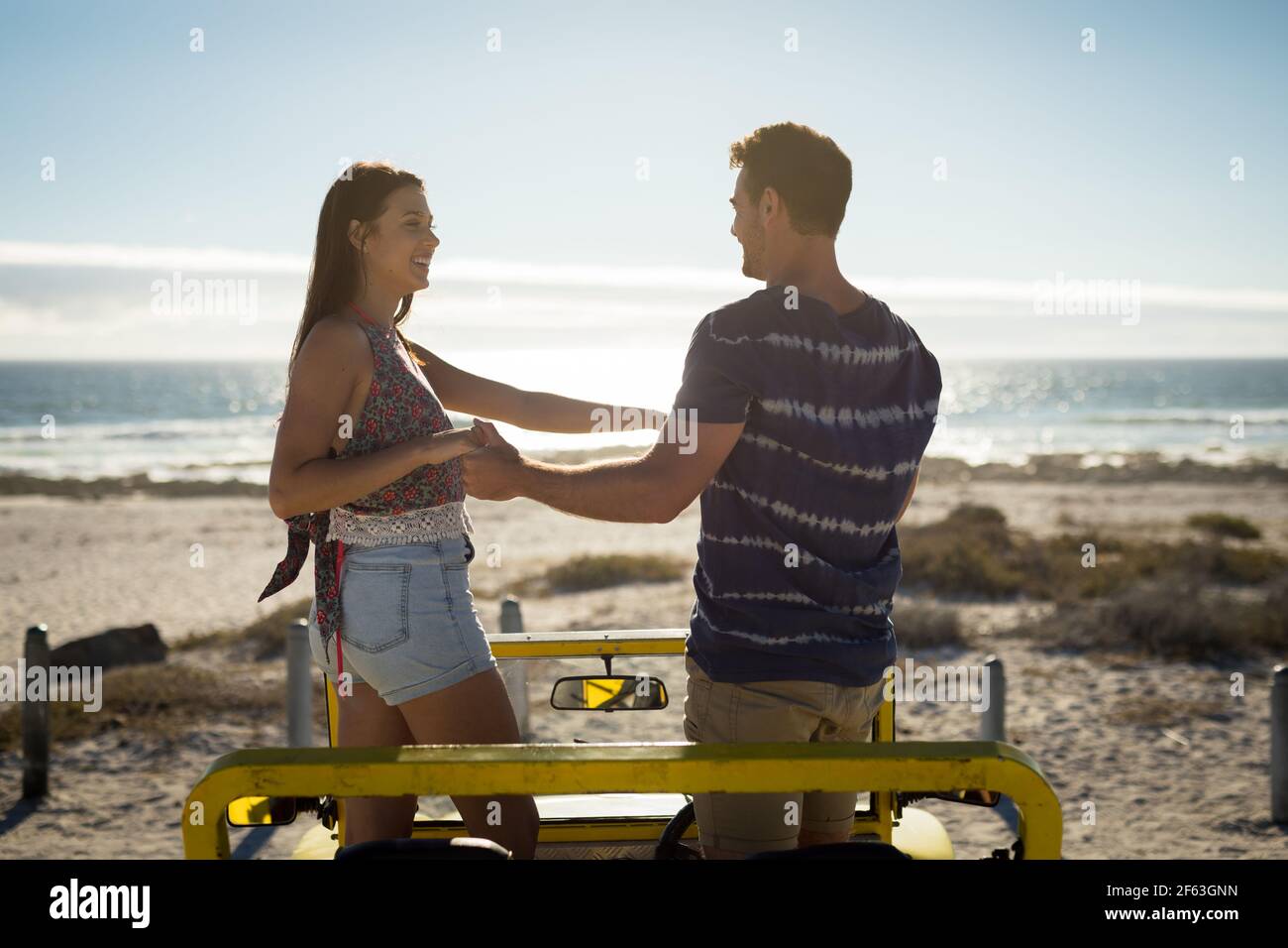 Couple de caucasiens heureux dans la plage buggy au bord de la mer holding mains Banque D'Images
