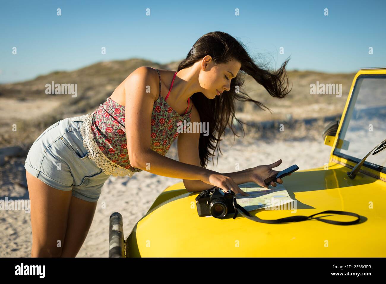 Bonne femme caucasienne lisant la feuille de route sur la plage buggy par mer Banque D'Images