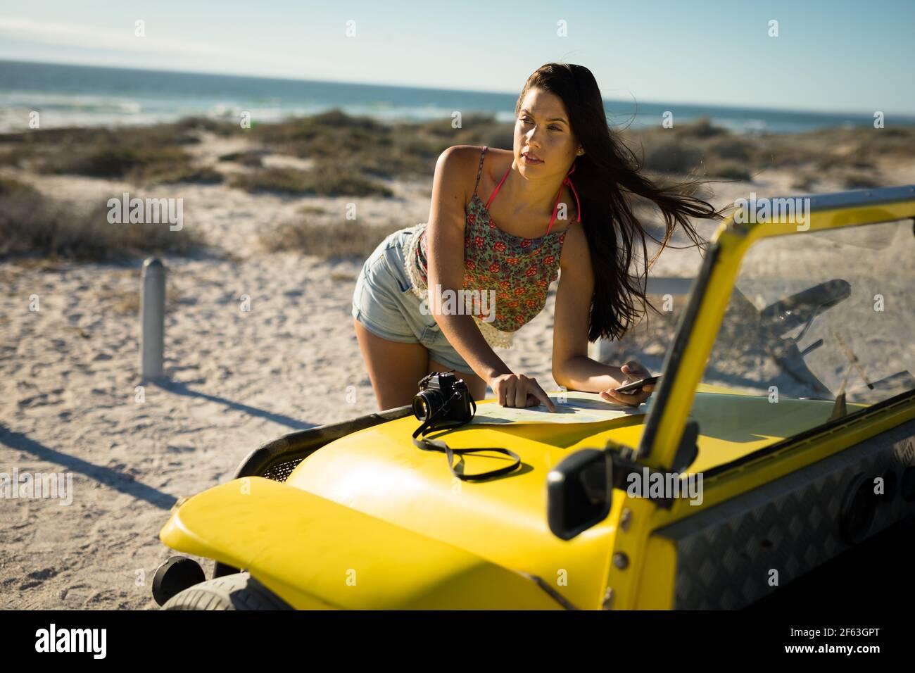 Bonne femme caucasienne lisant la feuille de route sur la plage buggy par mer Banque D'Images
