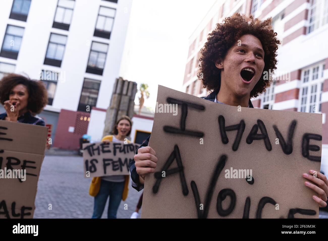 Un manifestant masculin de race mixte organise en mars une manifestation maison signez et criez Banque D'Images