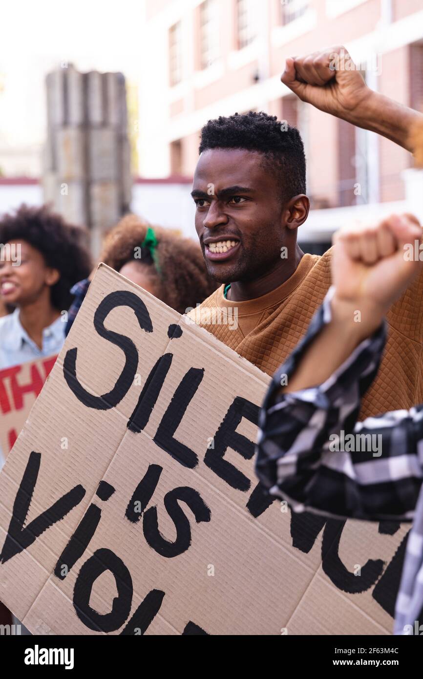 Homme afro-américain avec des manifestants le mars tenant des panneaux et lever les poings Banque D'Images