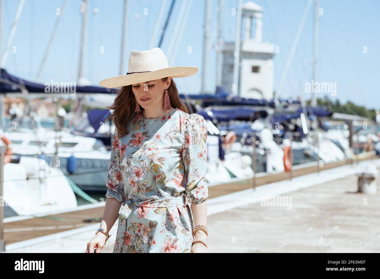 femme de voyage solo tendance en robe fleurie avec chapeau sur la jetée  Photo Stock - Alamy