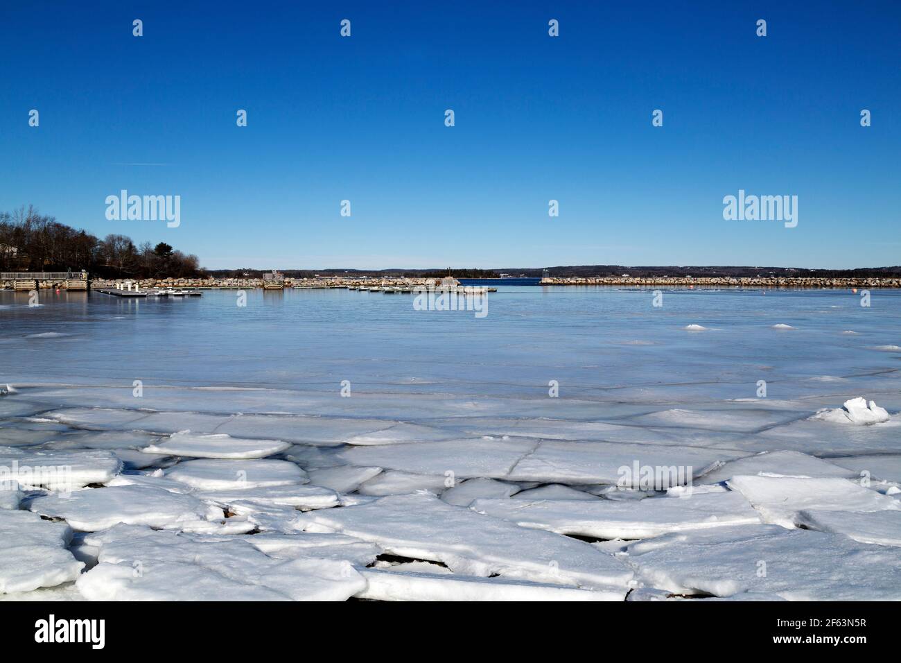 La glace en feuilles flotte dans l'anse partiellement gelée de Rafuses Cove, en Nouvelle-Écosse, au Canada. Un quai protège le port. Banque D'Images