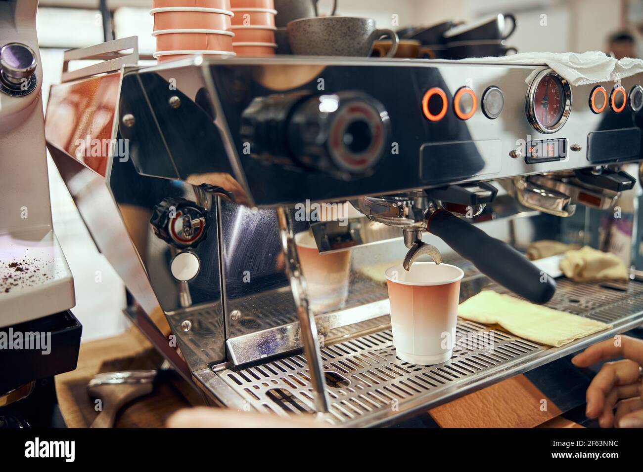 Espresso versé à la machine à café dans une tasse en carton. Préparation professionnelle du café Banque D'Images