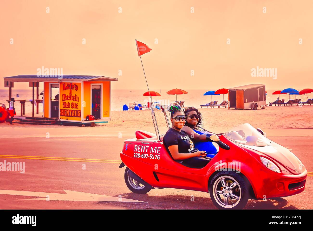 Les touristes conduisent une moto Scoot coupé à trois roues à Biloxi Beach, le 27 mars 2021, à Biloxi, Mississippi. Banque D'Images