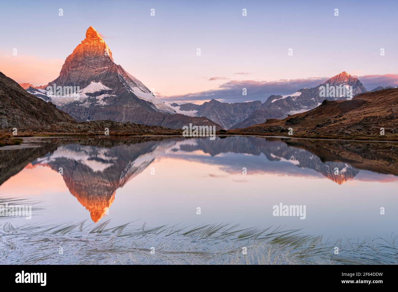 Ciel rose au lever du soleil au-dessus de Matterhorn miroir dans le lac Riffelsee, Gornergrat, Zermatt, canton du Valais, Suisse Banque D'Images