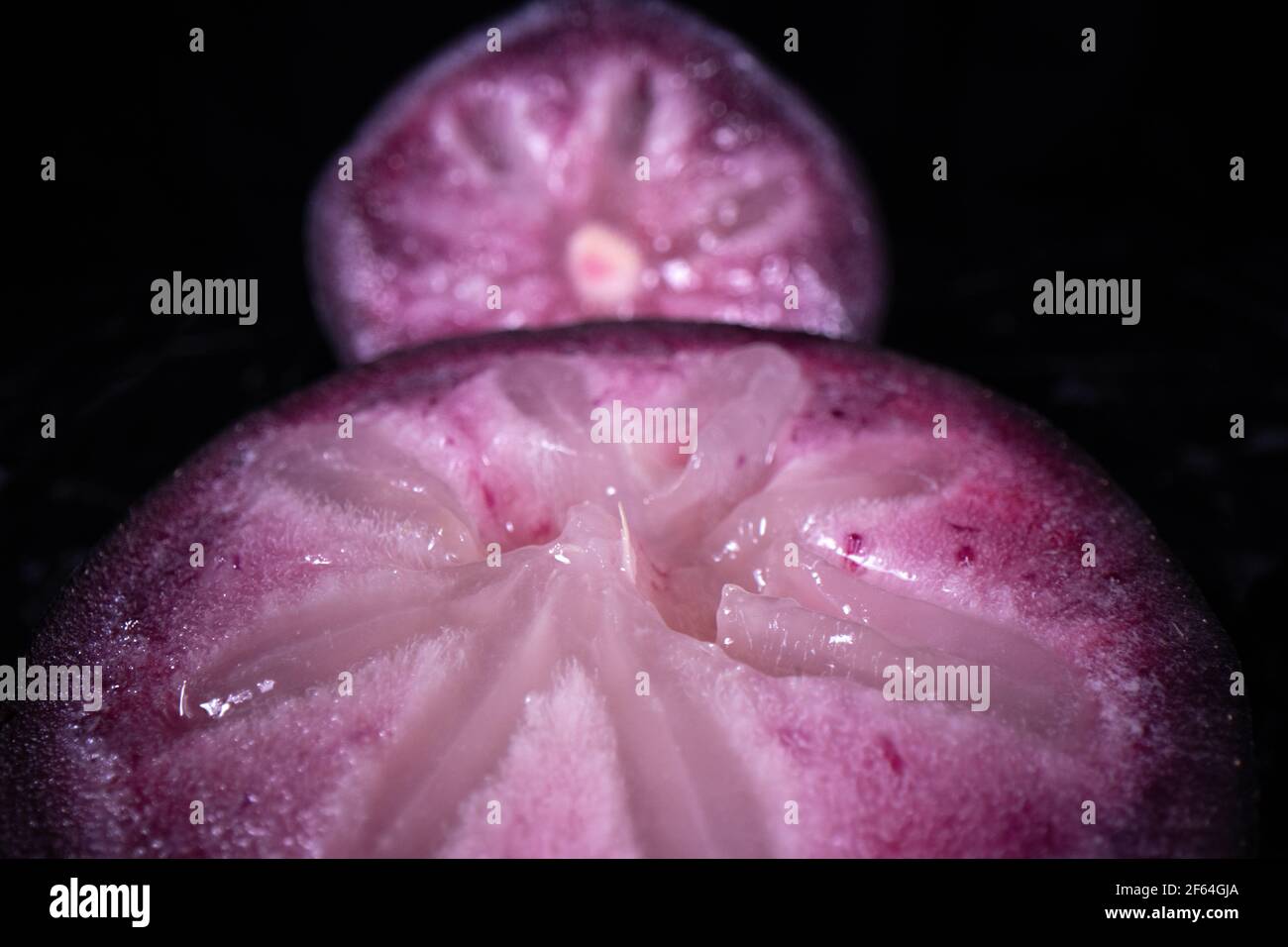 Une pomme bien mûre montrant les fruits colorés coupés en deux, un fruit populaire de saison aux Philippines. Banque D'Images
