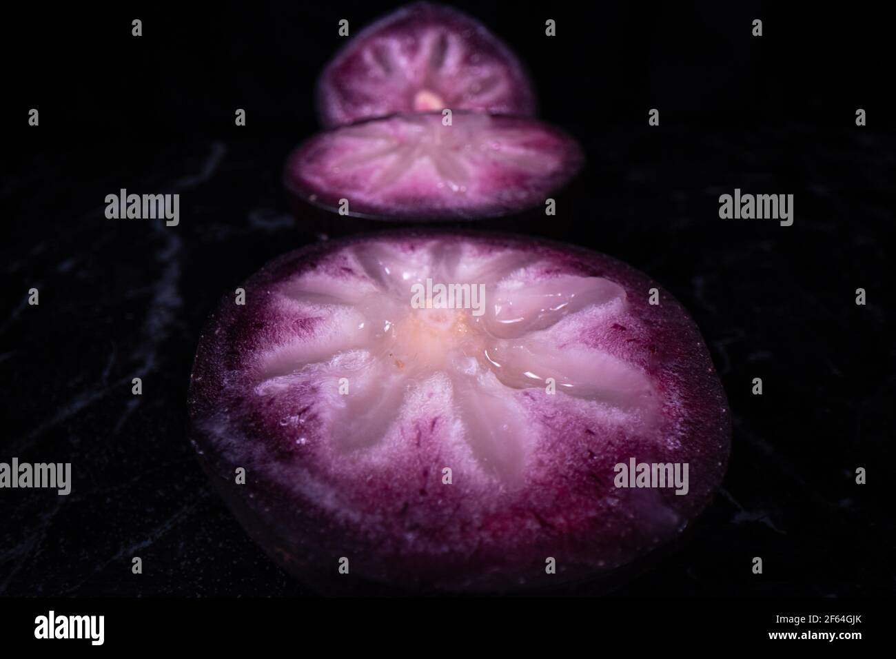 Une pomme bien mûre montrant les fruits colorés coupés en deux, un fruit populaire de saison aux Philippines. Banque D'Images