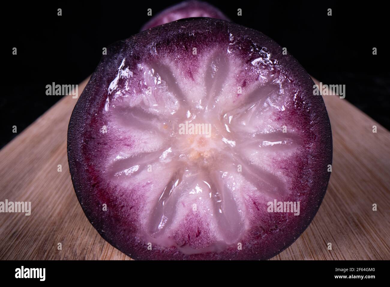Une pomme bien mûre montrant les fruits colorés coupés en deux, un fruit populaire de saison aux Philippines. Banque D'Images