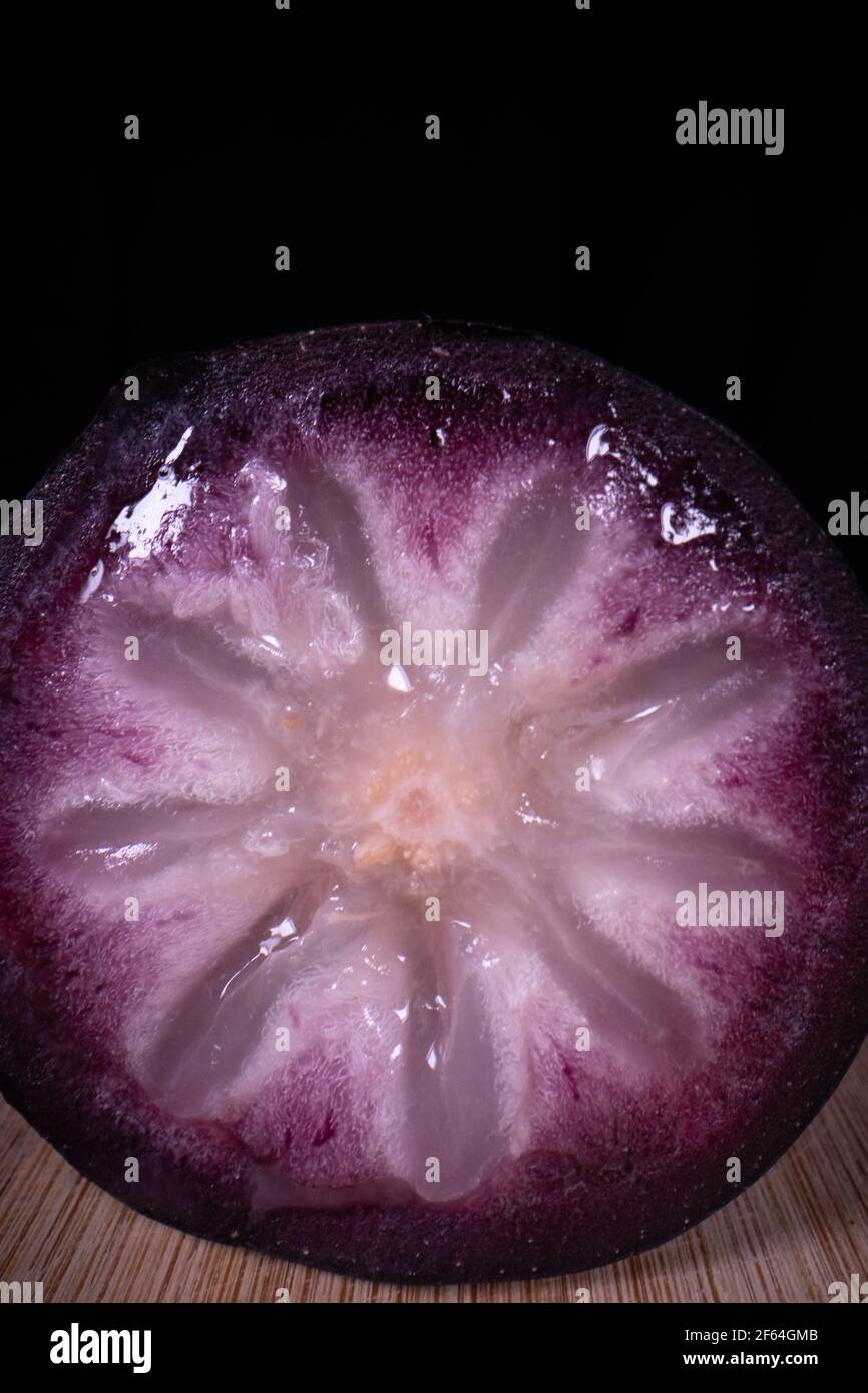Une pomme bien mûre montrant les fruits colorés coupés en deux, un fruit populaire de saison aux Philippines. Banque D'Images