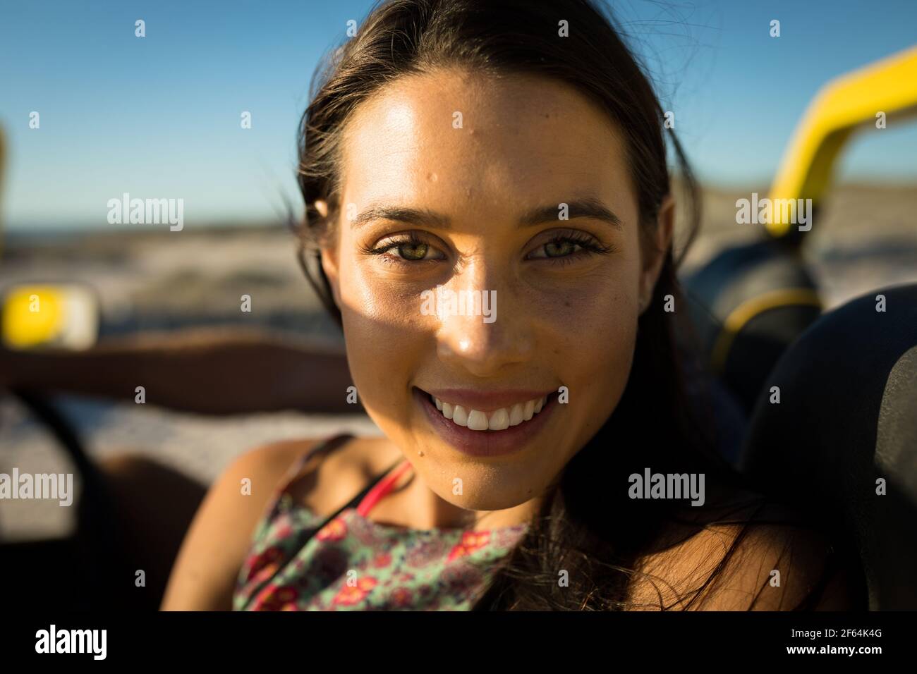Bonne femme caucasienne assise dans un buggy de plage au bord de la mer regarder l'appareil photo Banque D'Images