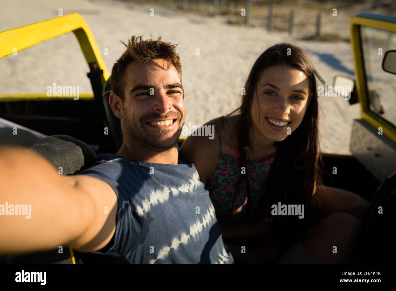 Heureux couple caucasien assis dans la plage buggy au bord de la mer prise de selfie Banque D'Images
