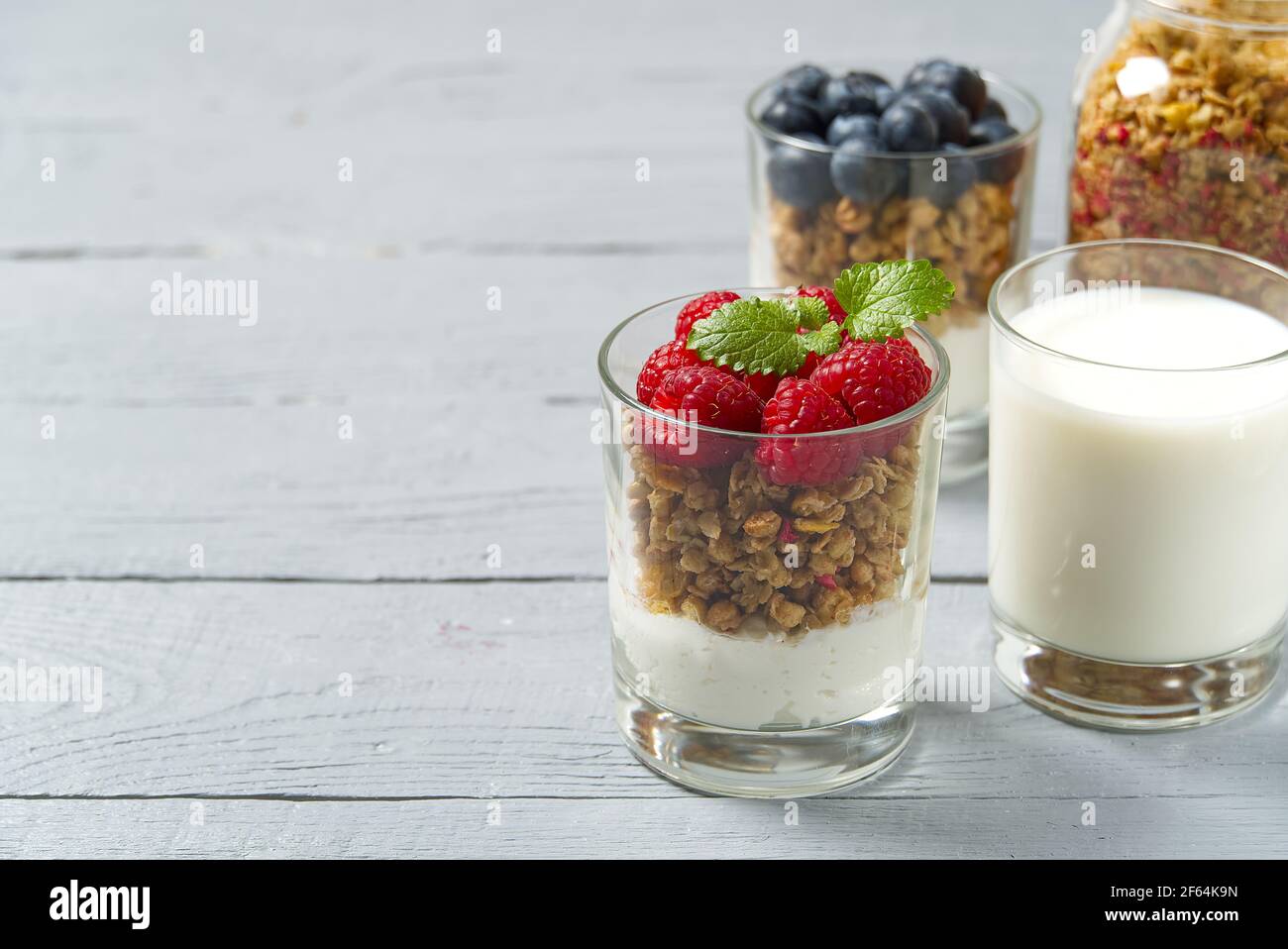 Yaourt avec granola et bleuets et framboises frais, en verre. Petit-déjeuner sain : yaourt à la sauce à la granola et aux baies Banque D'Images