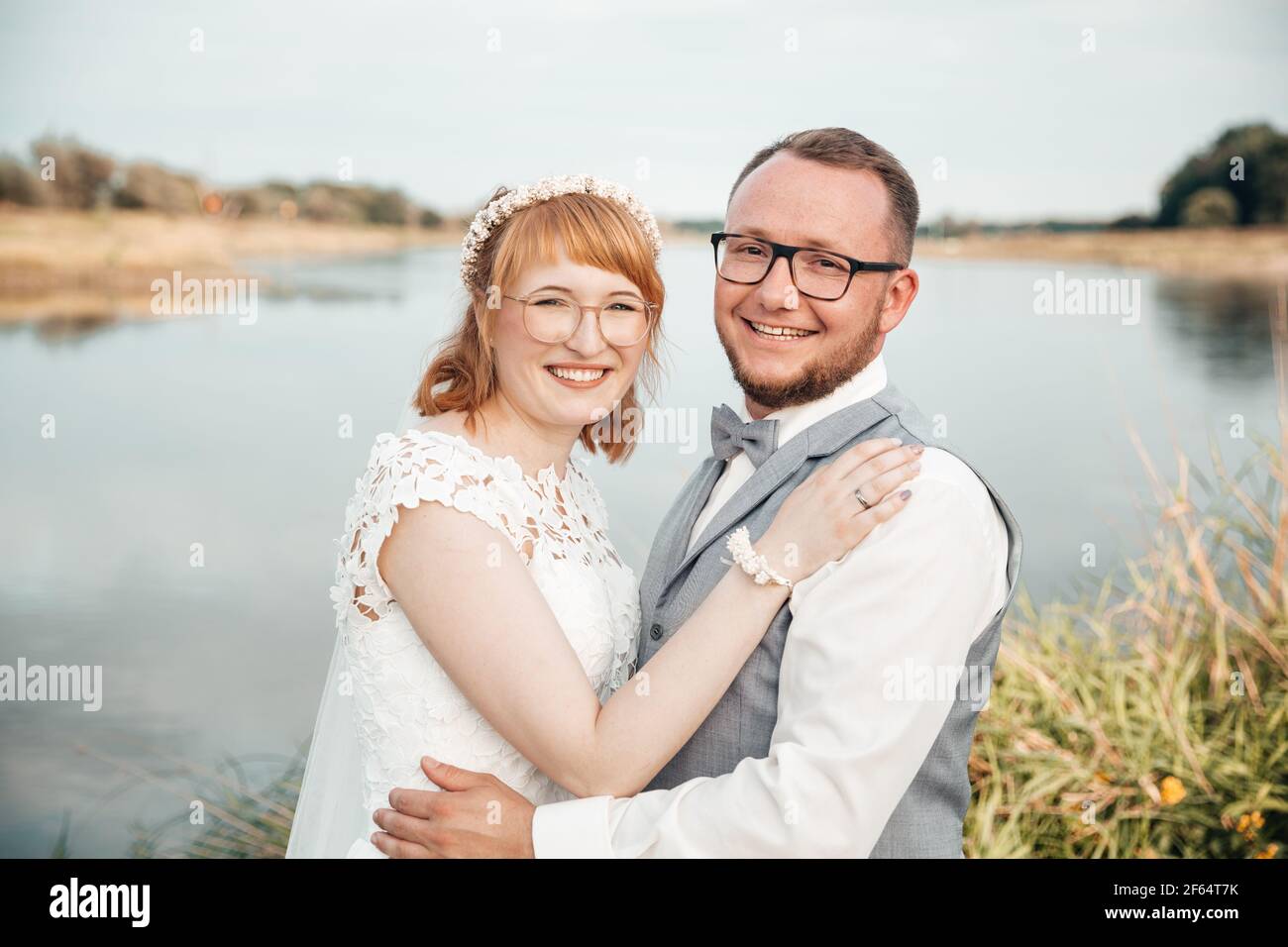 Couple de mariés heureux à côté d'une rivière Banque D'Images