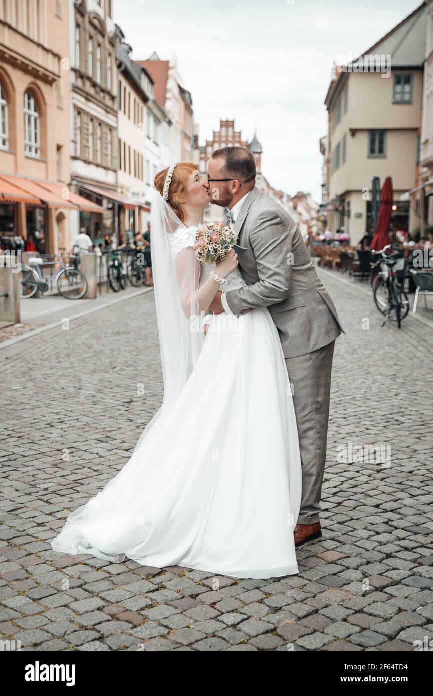 Couple de mariée embrassant au milieu de la rue Banque D'Images
