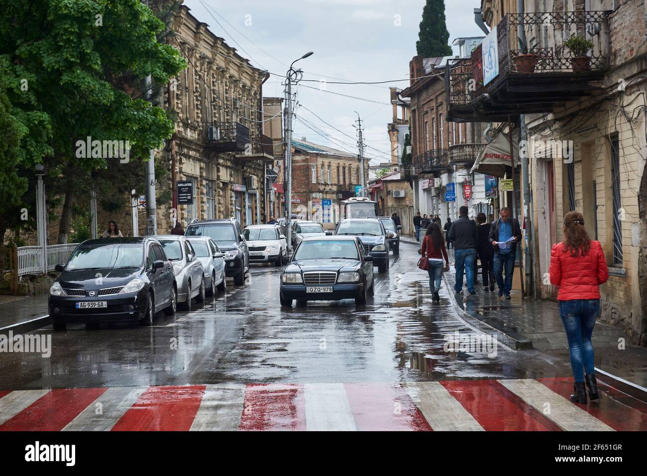 Rue Kutaisi par temps de pluie avec des voitures garées et des piétons à pied. Géorgie Banque D'Images