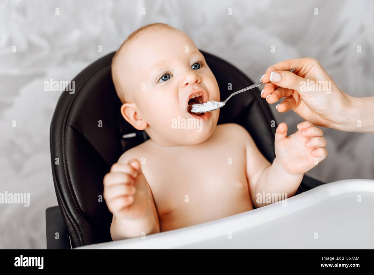 Maman Nourrit Un Bebe Drole A Partir D Une Cuillere Le Bebe Est Assis Dans Une Chaise Haute Photo Stock Alamy Maman Nourrit Un Bebe Drole A Partir D Une Cuillere Le Bebe Est Assis Dans Une Chaise Haute Photo Stock Alamy