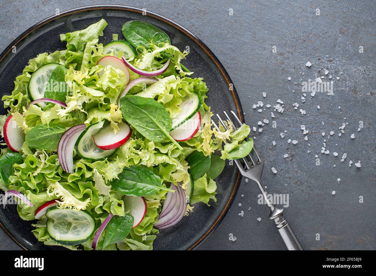 Salade verte saine avec légumes frais sur fond de table gris Banque D'Images