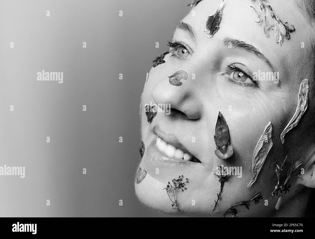 Femme souriante avec des fleurs sur son visage II Banque D'Images