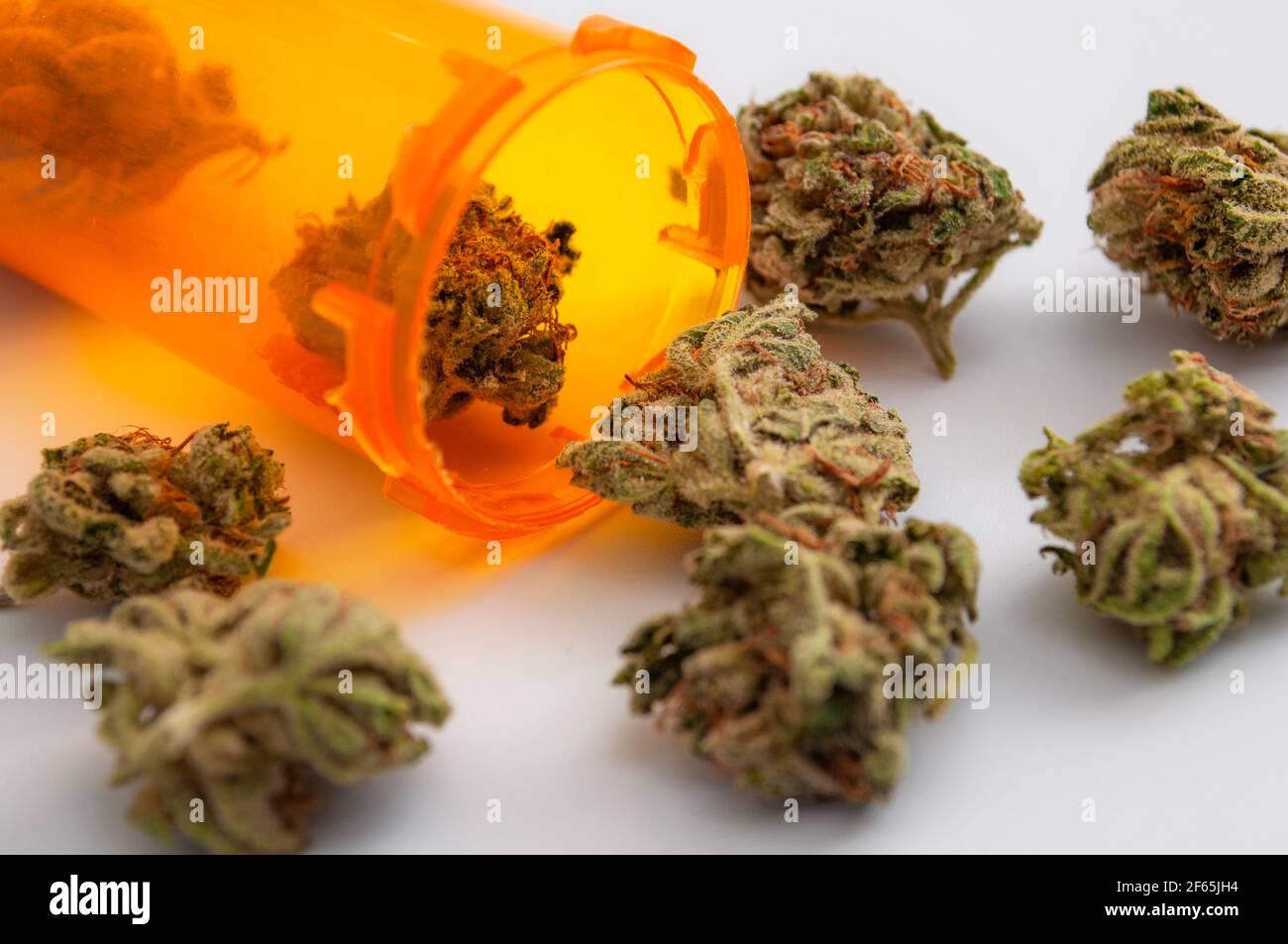 Application médicale de la plante de marijuana dans le traitement de la toxicomanie et thème de concept de mauvaises herbes légales avec bouteille de médecine orange en gros plan avec un canon médical Banque D'Images