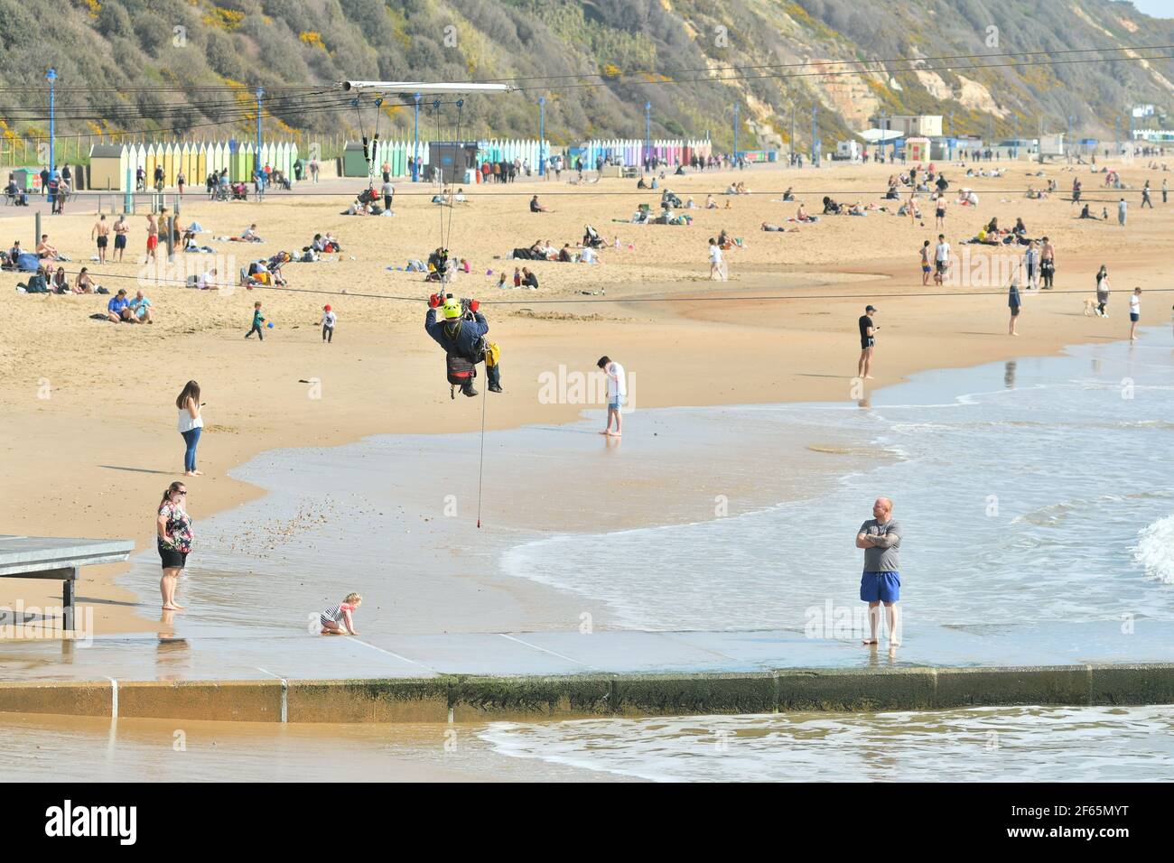 Bournemouth, Dorset, Royaume-Uni, 30th mars 2021, Météo. Une vague de chaleur printanière précoce Un employé de maintenance est suspendu à un câble du trajet de câble à glissière. Banque D'Images