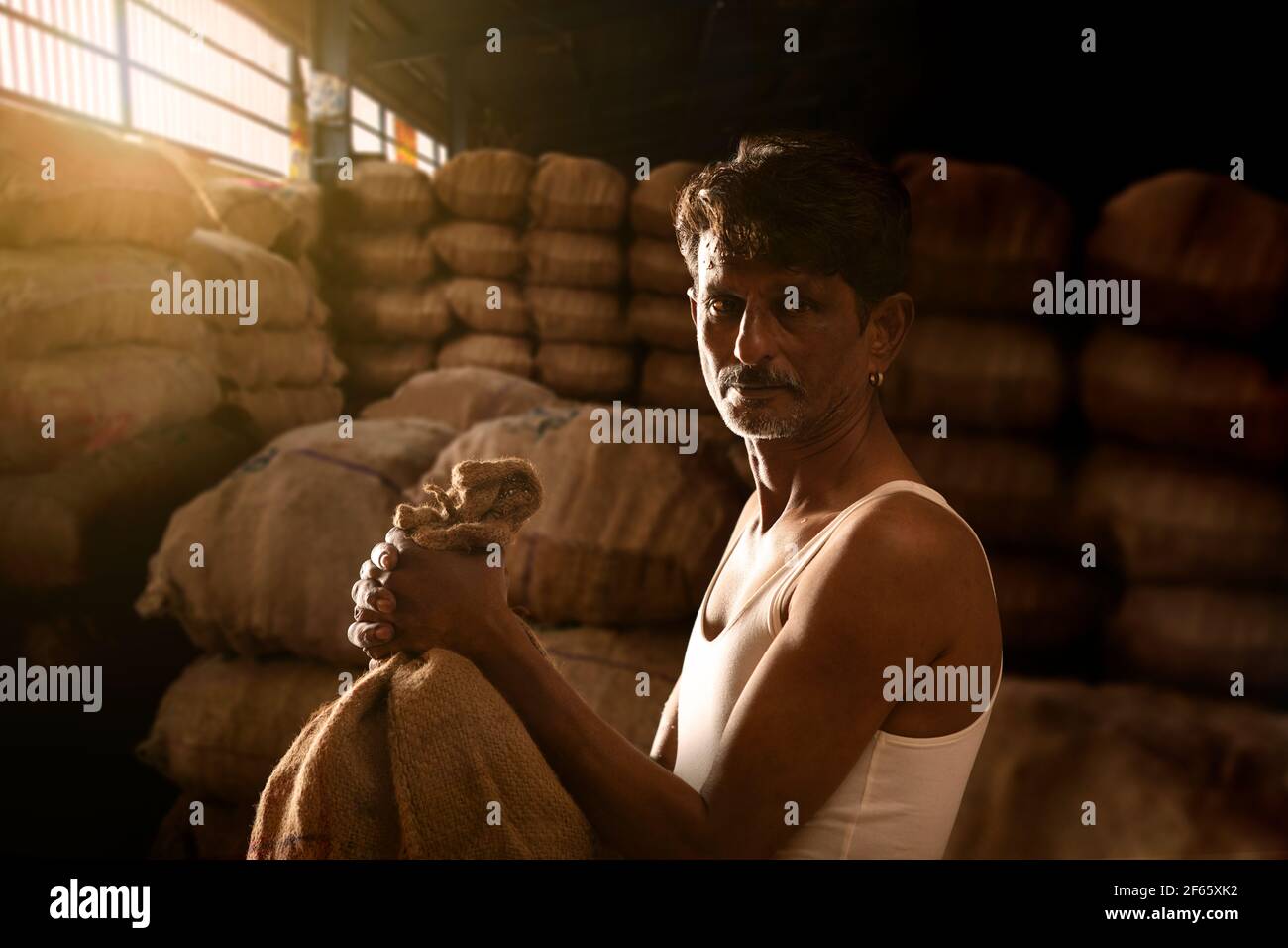 UN FERMIER AVEC SES PRODUITS À UN MANDI OU EN GROS MARCHÉ Banque D'Images