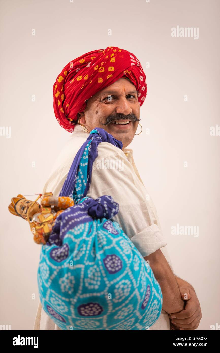 UN ARTISTE RURAL KATHPUTLI SE TOURNANT ET SOURIANT À LA CAMÉRA Banque D'Images