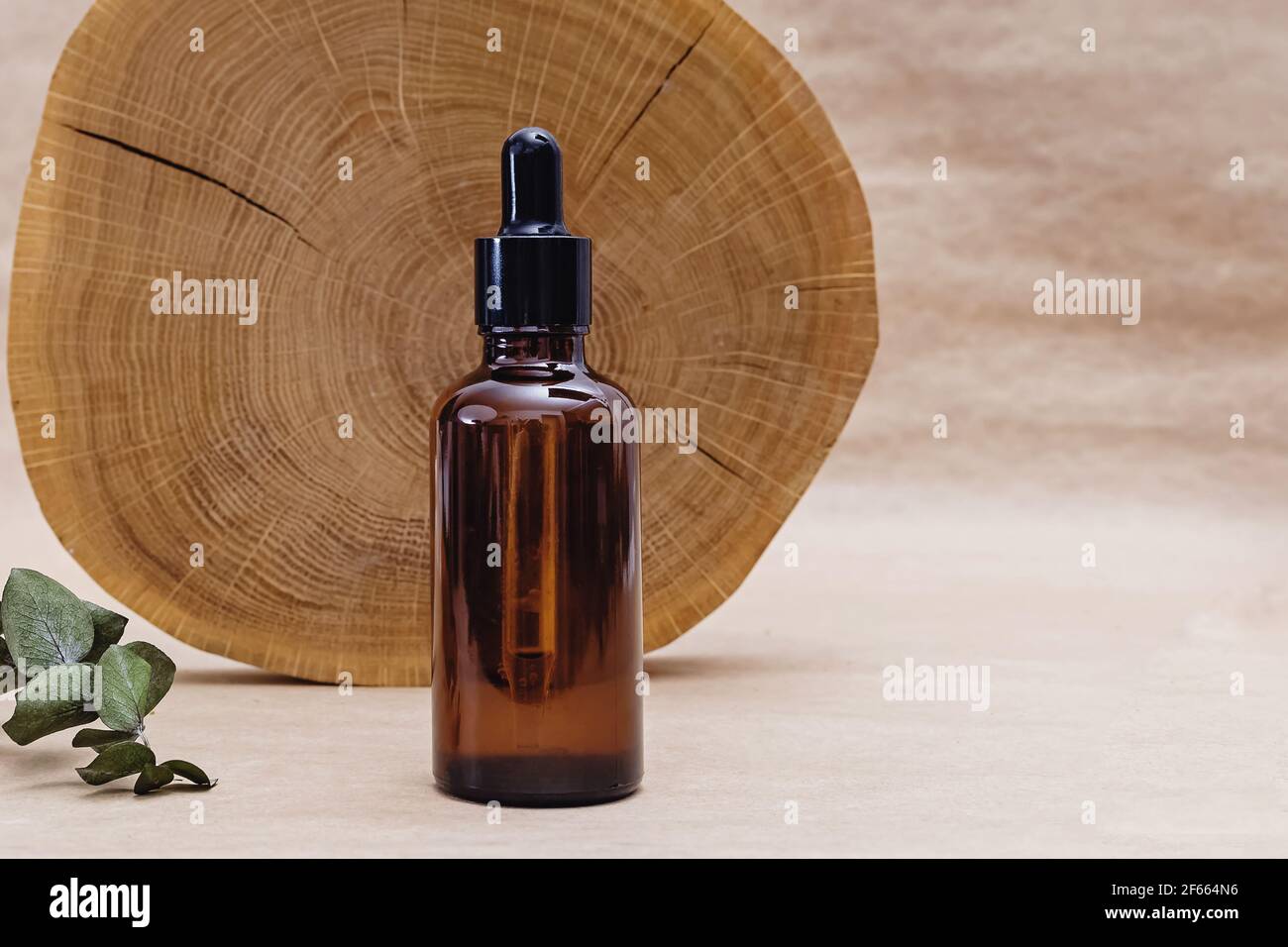 Flacon avec sérum facial et scie en bois Banque D'Images