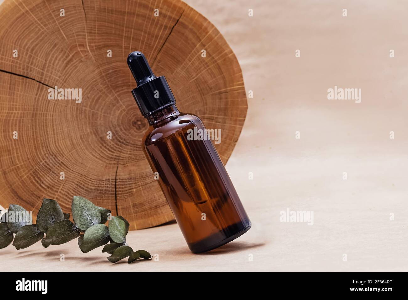 Flacon avec sérum facial et scie en bois Banque D'Images