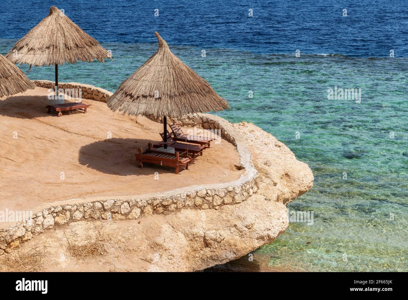 Plage de corail avec parasols en mer Rouge, Egypte Banque D'Images