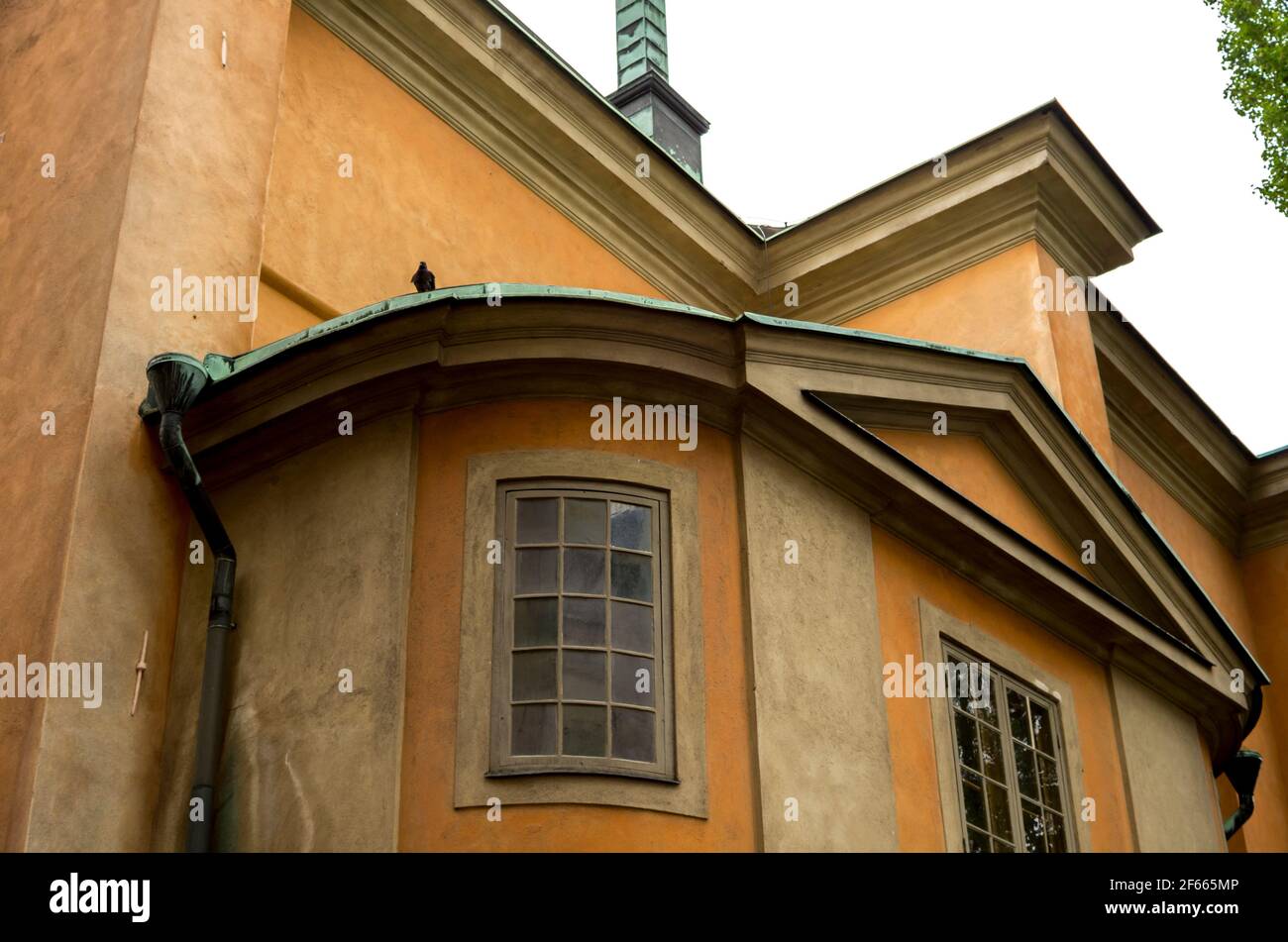 Détail du Storkyrkan (la Grande église) / Stockholms domkyrka (cathédrale de Stockholm) montrant des fenêtres dans la façade jaune / orange. Banque D'Images
