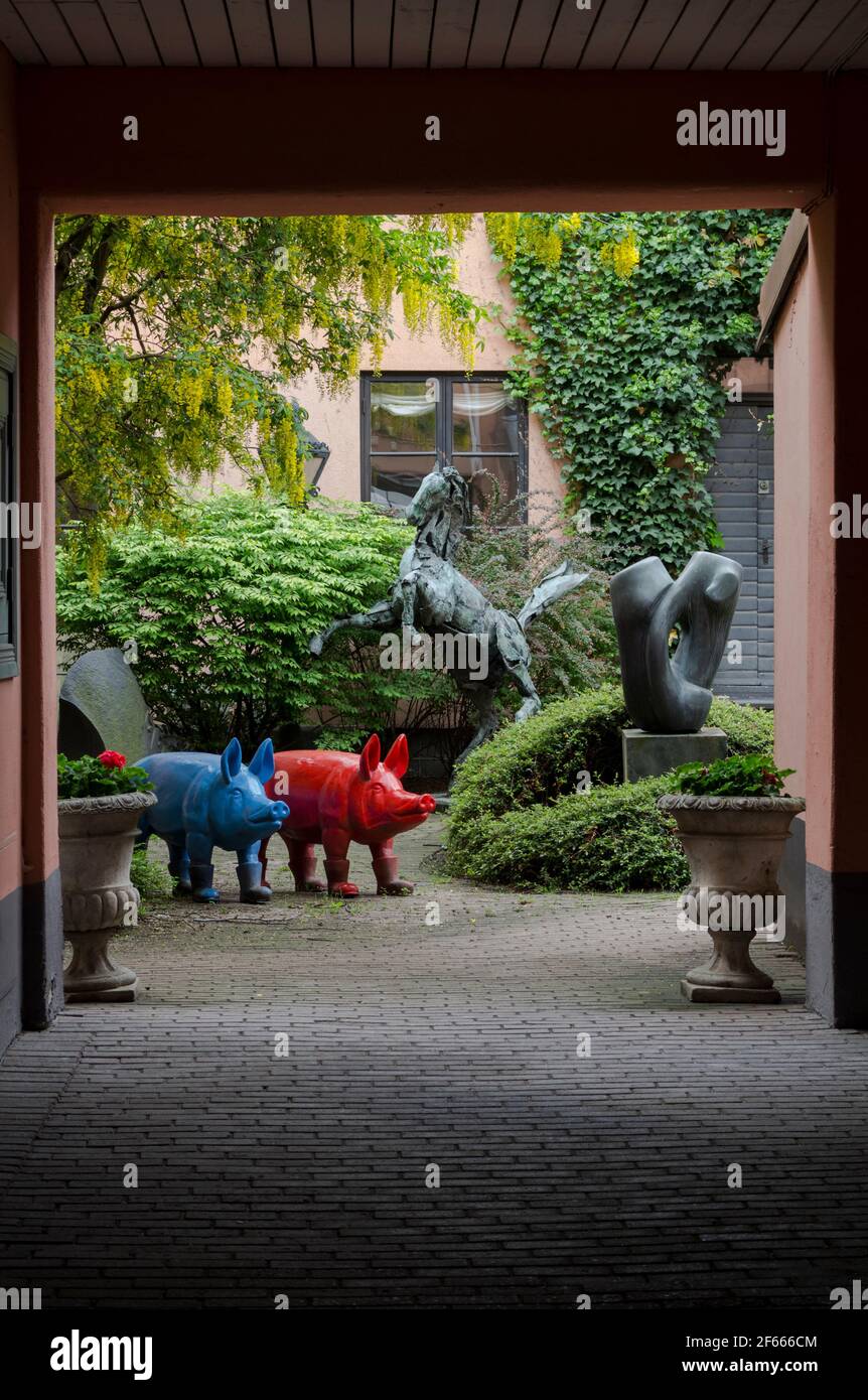 Une cour à Malmö, en Suède, avec des arbres, des grimpeurs et une gamme éclectique de sculptures, dont des cochons aux couleurs vives Banque D'Images