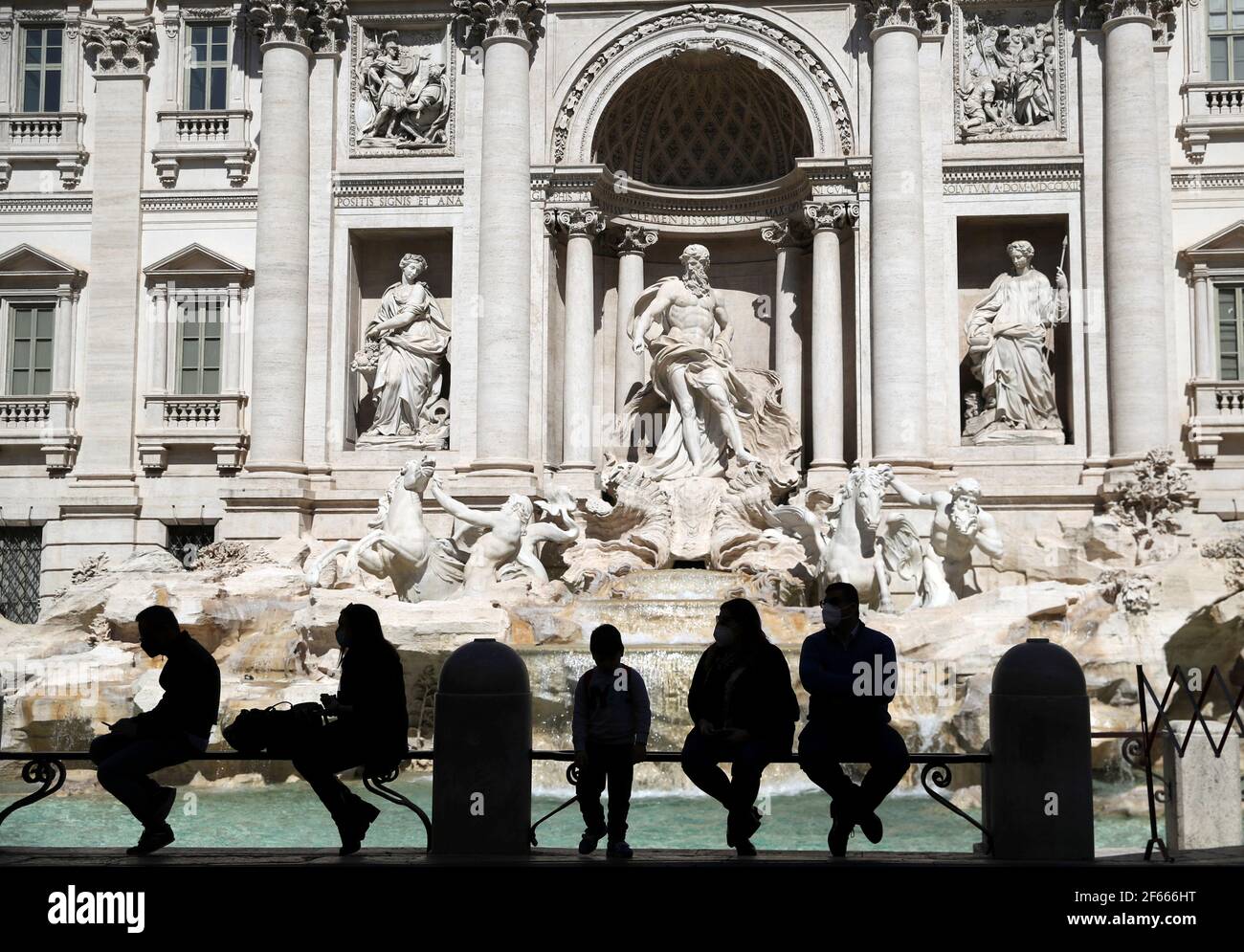 Les gens s'assoient en face de la fontaine de Trevi, les restrictions COVID-19 dans la région du Latium étant légèrement relaxantes, à Rome, en Italie, le 30 mars 2021. REUTERS/Yara Nardi Banque D'Images