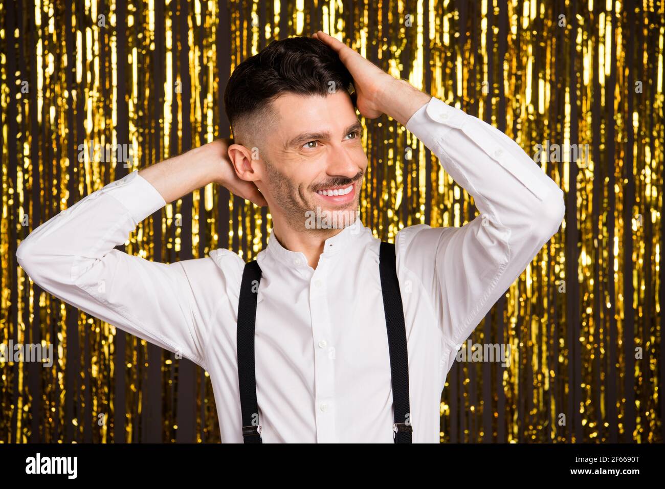 Photo de drôle adorable jeune homme porter des bras de chemise blancs tête  à la recherche de l'espace vide dansant un fond de paillettes dorées  isolées Photo Stock - Alamy