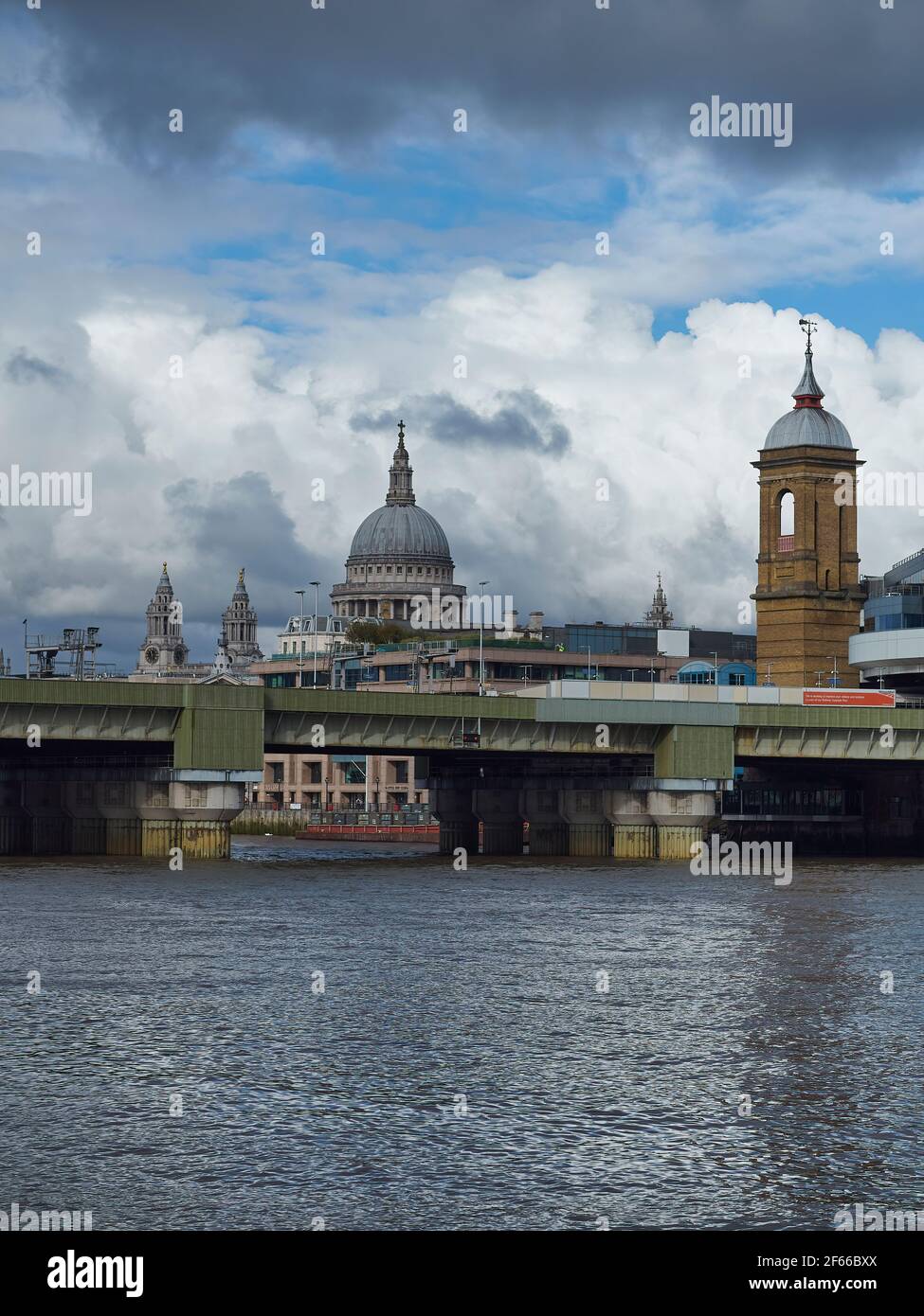 Une ligne d'horizon de la rive sud, montrant Cannon Street Bridge avec un train jusqu'à sa destination et le dôme de la cathédrale Saint-Paul en arrière-plan. Banque D'Images
