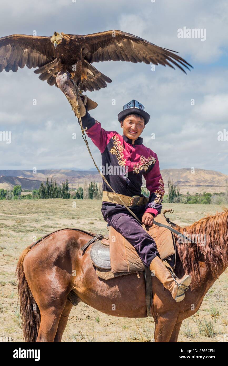 ISSYK KUL, KIRGHIZISTAN - 15 JUILLET 2018 : homme local avec son aigle à l'Ethnofestival Teskey Jeek, sur la côte du lac Issyk Kul, au Kirghizistan Banque D'Images