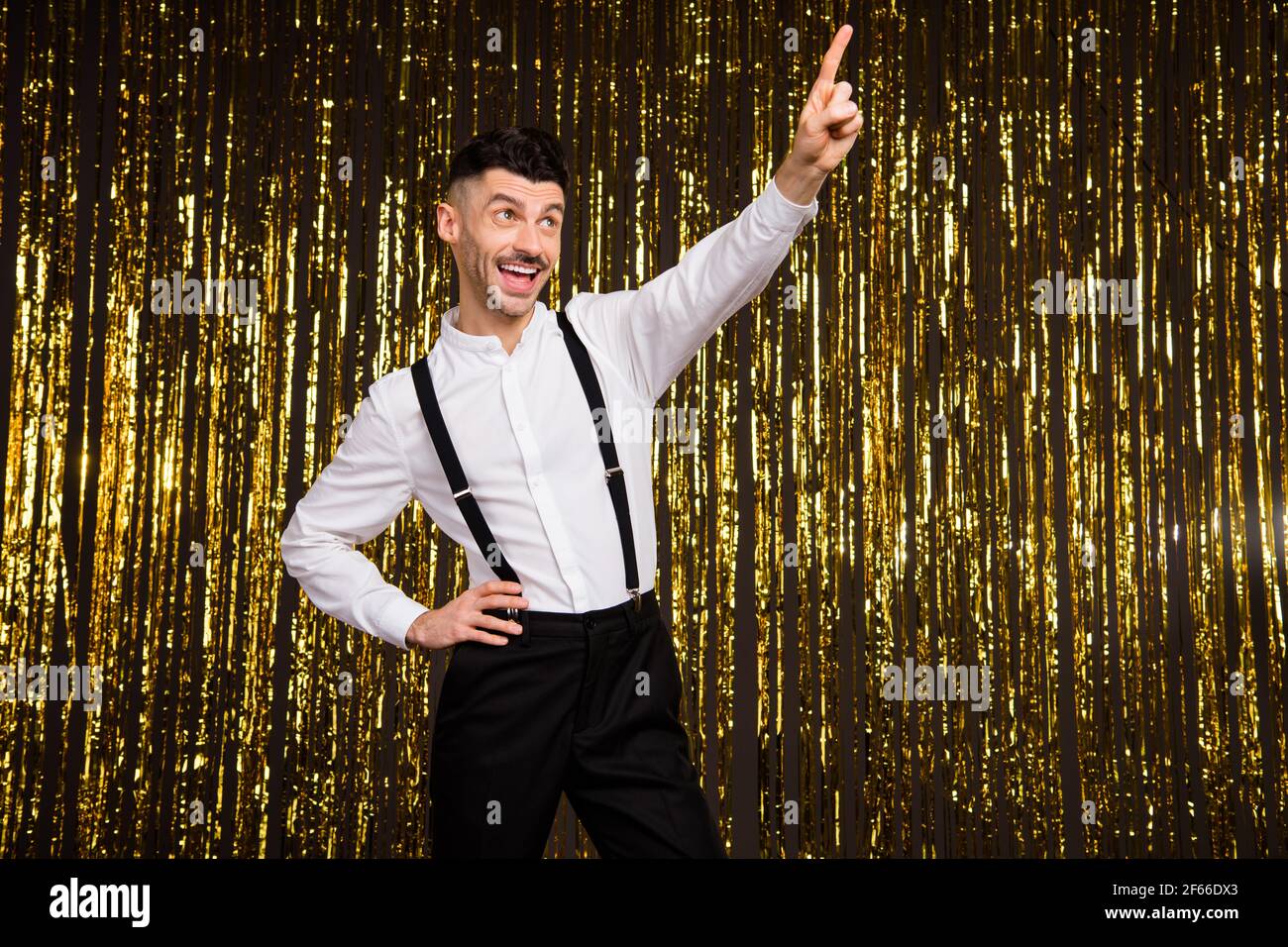 Photo de drole charmant jeune homme porter chemise blanche pointant danse des doigts sur fond dore scintillant isole Photo Stock Alamy