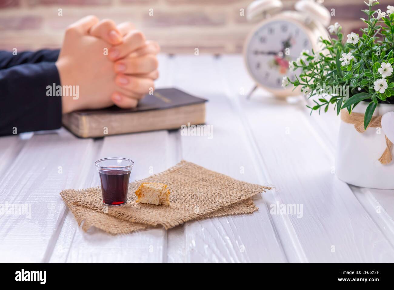 Jeune femme priant et prenant la communion - le vin et les symboles du pain de Jésus Christ sang et corps avec la Sainte Bible. Pâque de Pâques Banque D'Images