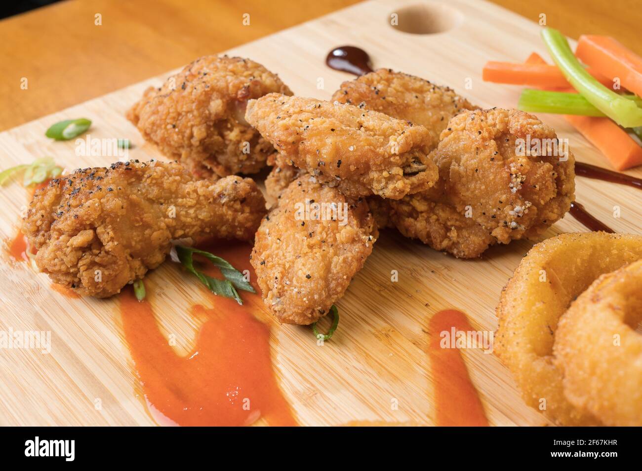 Ailes de poulet et rondelles d'oignon avec un pichet de bière. Banque D'Images