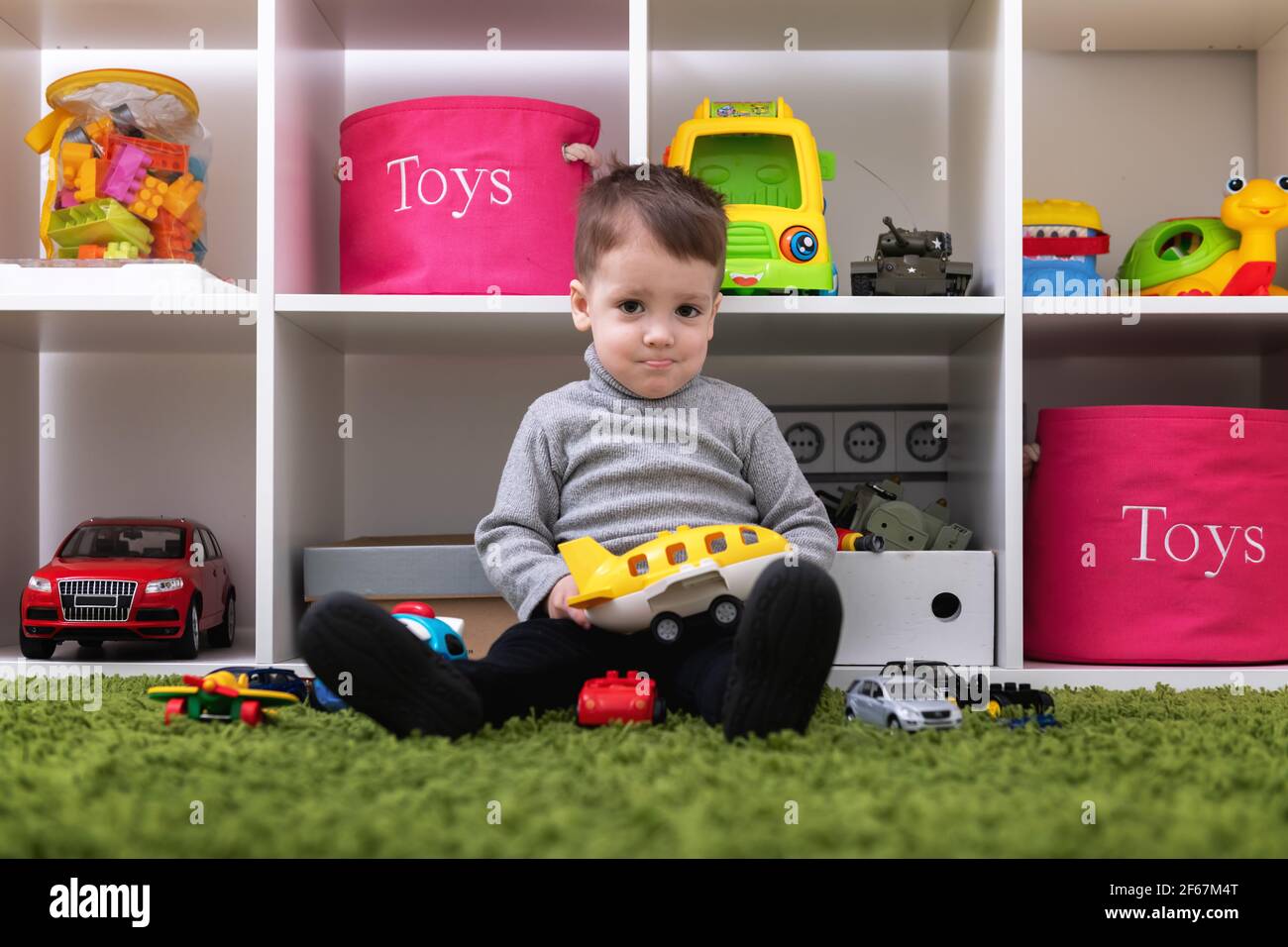 Le jeune garçon caucasien joue avec des jouets colorés Banque D'Images