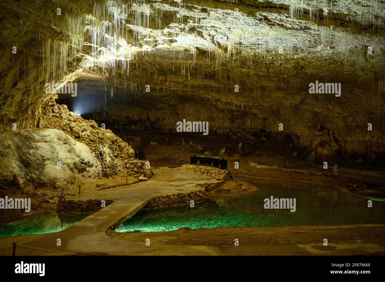 Passerelle avec pont au-dessus de l'eau verte émeraude dans une grotte décorée de stalactites. Vercors, France. Banque D'Images
