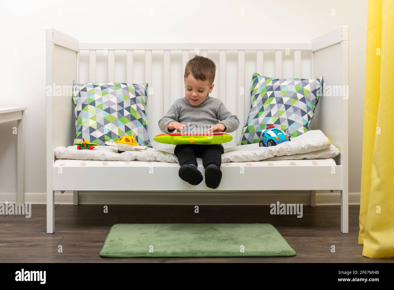 Le jeune garçon caucasien joue avec des jouets colorés Banque D'Images