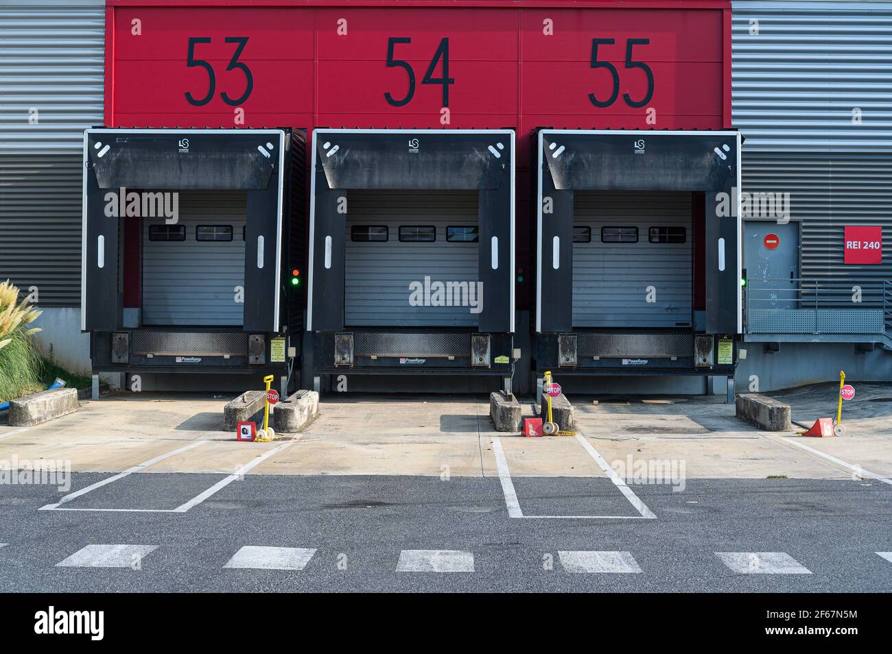 Trois baies de chargement modernes et vides avec portes fermées. Transport et logistique, bâtiment industriel moderne et technologie. Banque D'Images