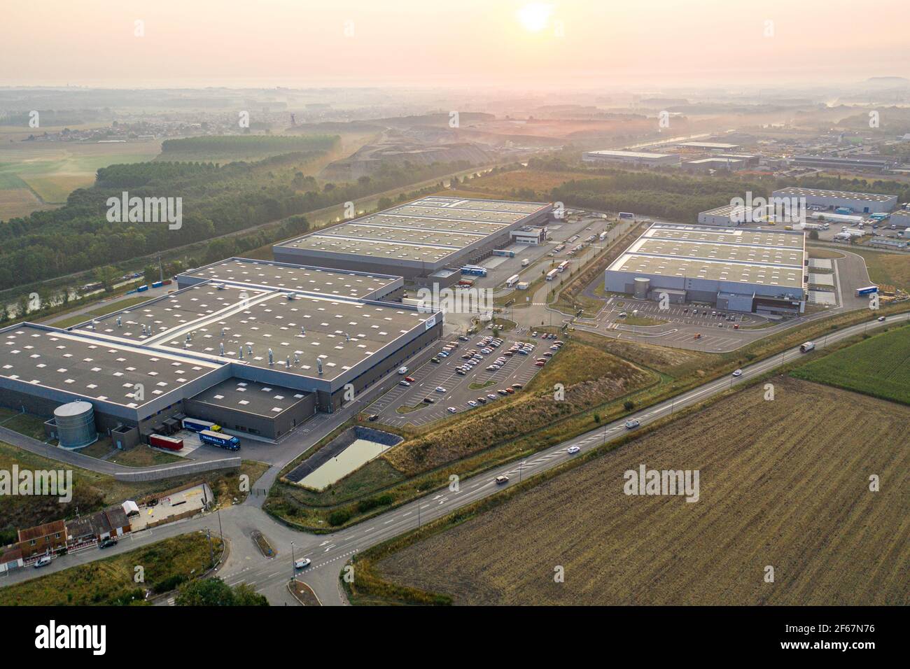 Vue d'ensemble sur la logistique de distribution aréale à Dourges à partir de drone. Grands entrepôts avec toit plat. Transport et logistique. Banque D'Images