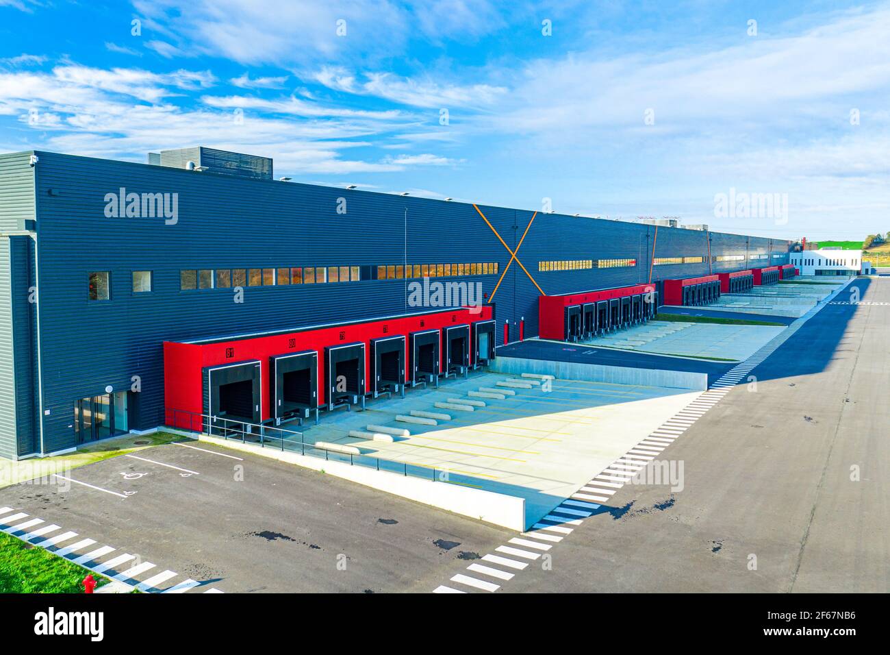 Grande vue sur la rangée de baies de chargement sur le nouveau grand hall de Puiseux logistique areal. Transport et logistique, bâtiment industriel moderne et technologie. Banque D'Images