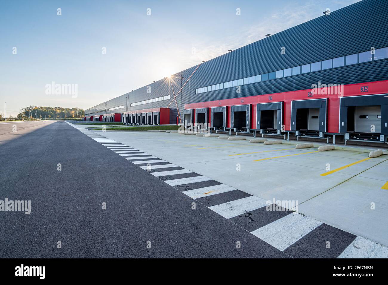 Large vue du matin de la longue rangée de baies de chargement vides dans la nouvelle zone logistique. Transport et logistique, bâtiment industriel moderne et technologie. Banque D'Images