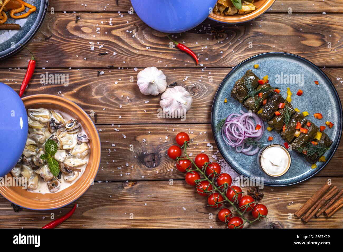 Dolma dans des feuilles de raisin sur un plateau et des boulettes de champignons sur un fond décoré d'épices, piments, tomates cerises. Le plat du Banque D'Images