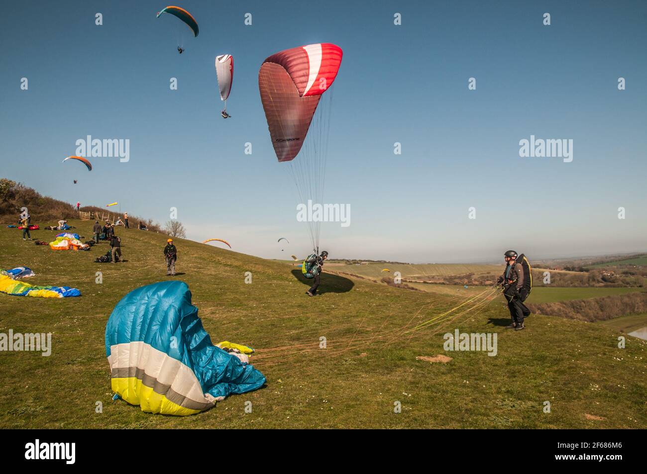 High and Over, Seaford, East Sussex, Royaume-Uni. 30 mars 2021. Le changement de vent en direction de l'est amène les pilotes de parapente à l'endroit pittoresque au-dessus de la vallée de Cuckmere. Crédit : David Burr/Alay Live News Banque D'Images