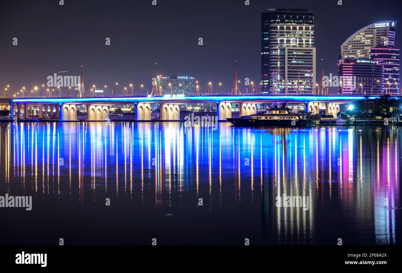 Magnifique vue nocturne sur le pont lumineux de la baie d'affaires de l'autre côté de l'eau avec des reflets entourés de majestueux gratte-ciel capturés à Dubaï. Banque D'Images